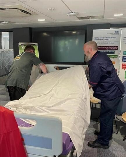 Staff demonstrating how to use a hospital slide sheet Staff demonstrating how to use a hospital slide sheet