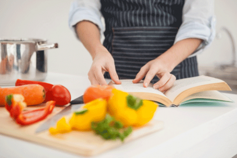 Chef preparing fresh veg, looking up recipe.