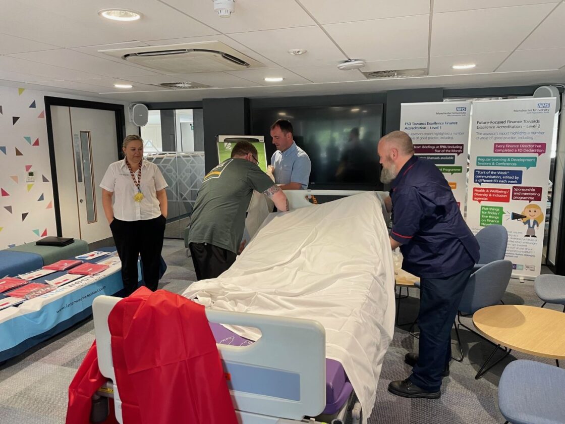 Staff demonstrating how to use a hospital slide sheet