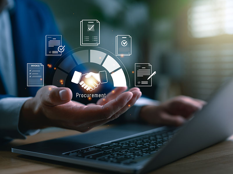 Person at a laptop with procurement icons in his hand