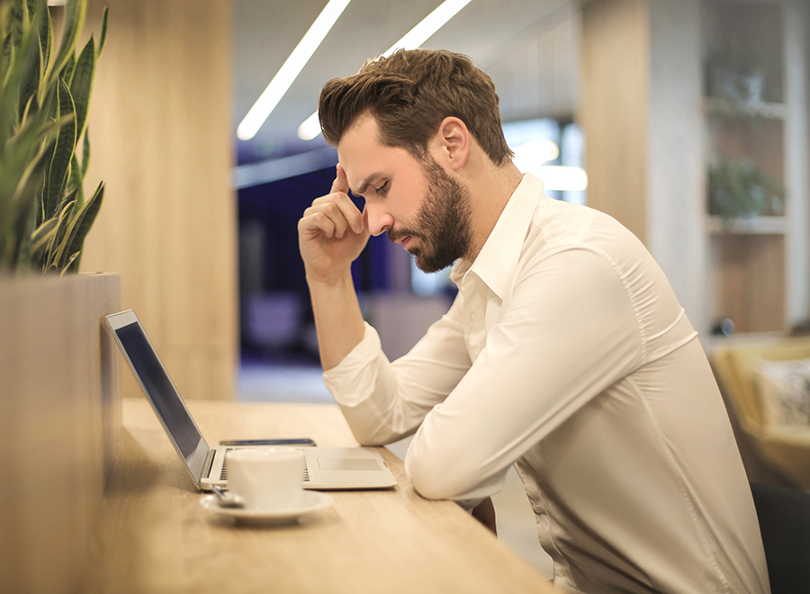 Person studying a laptop with a coffee on their desk