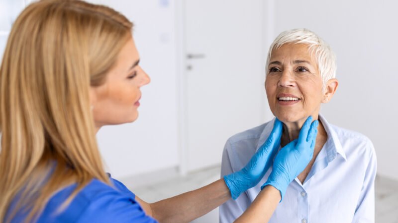 Clinician checking patient neck healthcare