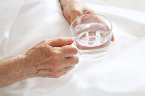 Patient holding glass of water