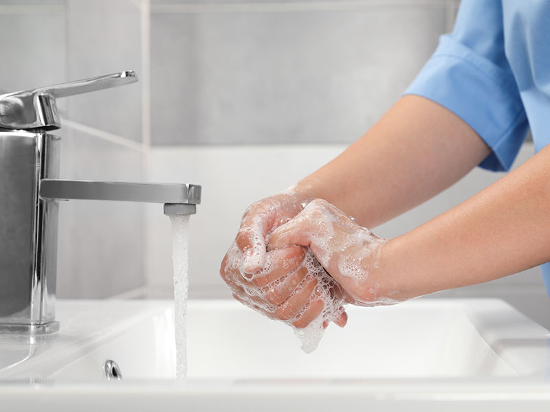 Clinician washing hands with water from tap Clinician washing hands with water from tap