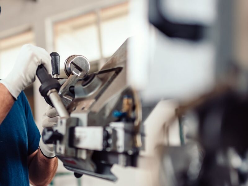 Worker with gloves using hand operated machine Worker with gloves using hand operated machine