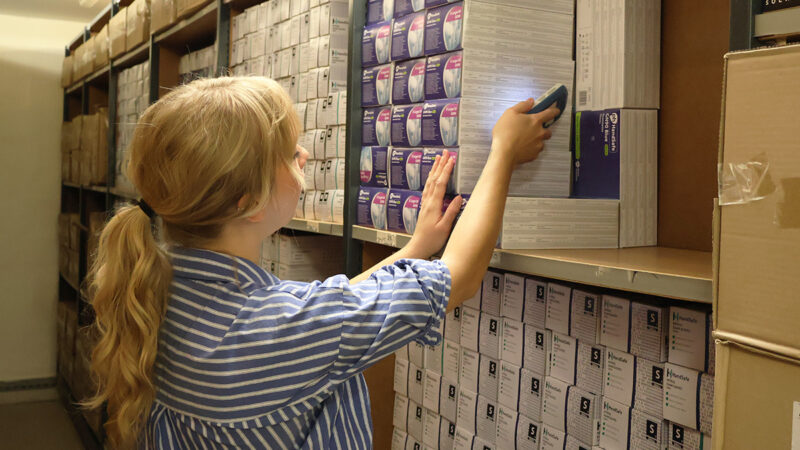 Scanning products on shelves in storage room in healthcare setting Scanning products on shelves in storage room in healthcare setting