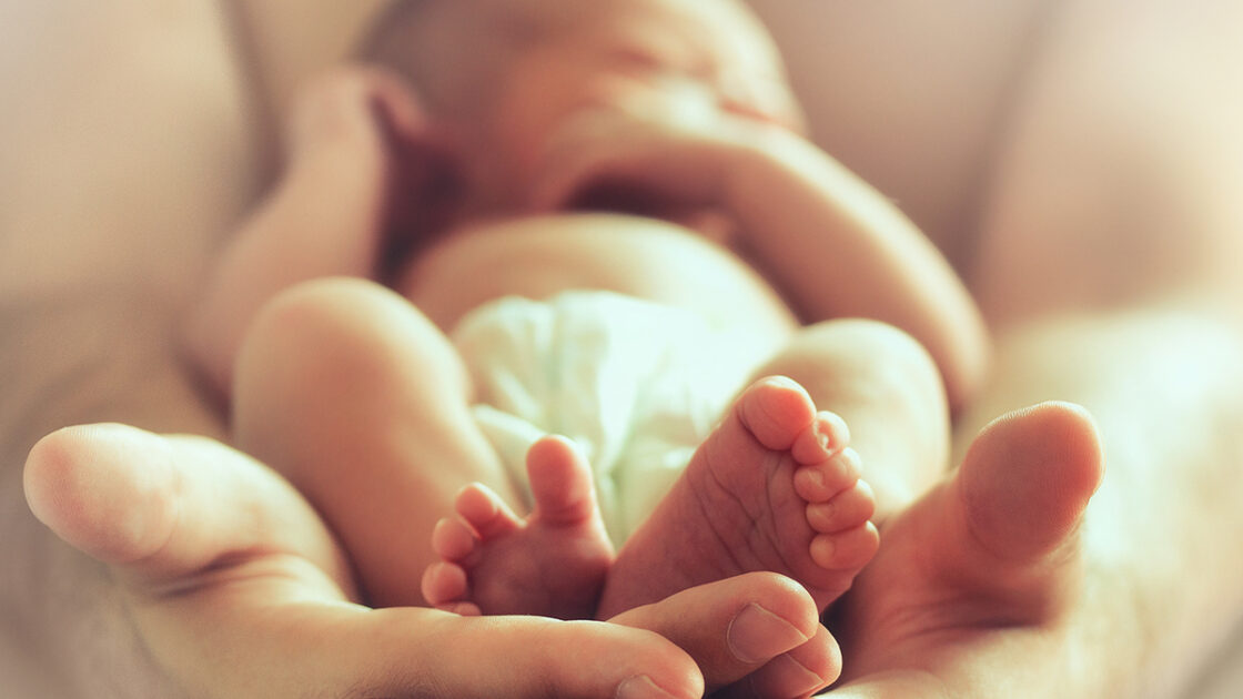 Newborn baby held in hands