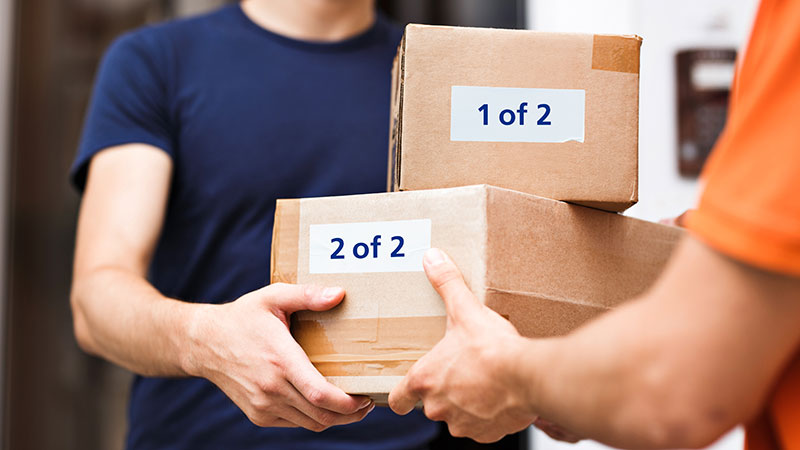 Image of man handing two packages to another man