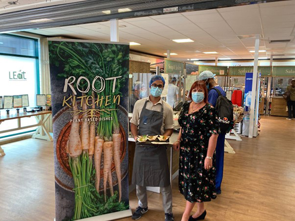 Root Kitchen Banner with LRI team showcasing food prepared at pop-up event. 