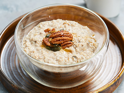 A bowl of porridge with some pecan nuts