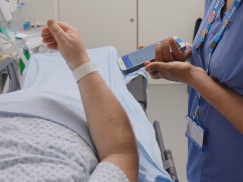Scanning patient wristband in hospital ward treatment room Scanning patient wristband in hospital ward treatment room